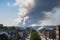 pollutant cloud hanging over industrial town, with smokestacks in the background