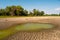 Polluted water and cracked soil of dried out lake during drought