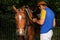 Polo equipment. Man saddling a polo horse.