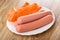 Polyethylene shell and peeled sausages in plate on table