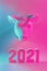 Polygonal paper bull head and numbers 2021 in neon light, modern symbol of the year