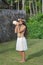 Polynesian Cook Islander woman blowing conch shell in Rarotonga