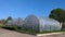 Polythene tunnel as a plastic greenhouse in an allotment with growing vegetables