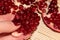 Pomegranate berries on a beige wooden background. Pomegranate