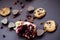 Pomegranate, cookies, raisins and chocolate hearts on a dark background.