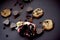Pomegranate, cookies, raisins and chocolate hearts on a dark background.