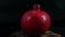 Pomegranate fruit on a black background spins around itself