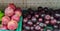 Pomegranate fruits Punica granatum and plums Prunus domestica displayed for sale in supermarket shelves. Tropical fruits.