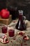 Pomegranate juice in a decanter and glasses and pomegranate fruit slices and seeds