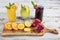 Pomegranate juice lemonade and orange juice served on a wooden serving tray on a wooden table