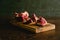 Pomegranate pieces on a cutting board on a dark background