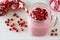 Pomegranate raspberry smoothie in a jar glass on marble