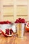 Pomegranate seeds in a metal bucket on the wooden background