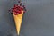 Pomegranate seeds in waffle cone on dark background
