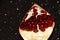 Pomegranate slice with berries on a black background. Brilliant background with berries