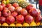 Pomegranate and tropical fruits, bananas, pineapples, lemons, citrus fruits on display at market.