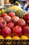 Pomegranate and tropical fruits, bananas, pineapples, lemons, citrus fruits on display at market.