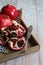 Pomegranates stacked one after the other on the wood and one front opened with seeds and knife