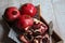 Pomegranates stacked one after the other on the wood and one front opened with seeds and knife