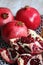 Pomegranates stacked one after the other on the wood and one front opened with seeds and knife