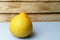 The pomelo is packed in a plastic net on a blue background