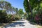 Pompeii, Company, Italy - June 25, 2019: A street surrounded by lush green trees and flowering shrubs under a generous Italian