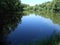 Pond behind the forests with reflections in clear weather.