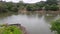 A Pond with big volume of water . There is a vegetation .