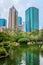 Pond and flamingos at Kowloon Park with skyscrapers behind