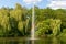 Pond, lake in the park, nature reserve, recreational area with fountain in the middle and with beautiful green trees in the backgr