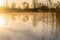 A pond with reflections and steam or mist at sunrise.