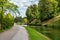 A pond in Snelli park, Tallinn, Estonia. Green trees and sidewalk on summer day with clouds