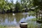 Pond. Summer. The boat stands on the shore under a green spreading tree