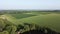 Pond with trees along banks among agricultural field, aerial view