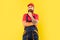 pondering bearded man plumber in work clothes on yellow background