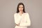 pondering businesswoman in white shirt on grey background, portrait