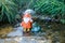 Pondlife..  orange gnome with umbrella and raingear and green porcelain frog