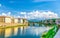 Ponte alle Grazie bridge over Arno River blue reflecting water, PromoFirenze and buildings on embankment promenade in Florence