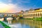 Ponte Vecchio bridge with colourful buildings houses over Arno River reflecting water in Florence