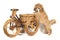 Poodle apricot puppy stands with its front paws on a wooden toy bike and looks into the camera. Isolated