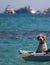 Poodle sitting in an inflatable canoe on the blue sea