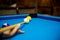 Pool balls on the blue felt pool table with player hands and pool cue stick. Indoor sports. sport and gambling concept.