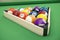 Pool billiard balls in a wooden rack, commonly used starting position, 3D illustration on green background.