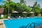 Pool with blue water in the tropical garden. beach chairs and umbrellas near a large pool. villa in the tropics.