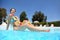 In pool in day-time woman sits in swimming suit