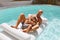 Pool. Father And Son Sunbathing And Floating On Inflatable Mattress. Dad Hugging And Comforting Kid.