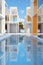 A pool in front of a row of white and orange buildings. Generative AI image.