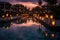 A pool with lanterns lit up at night