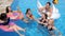 Pool party company of youth on inflatable rings with alcoholic drinks are resting in Poolside on summer vacations