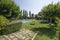 Pool and straw umbrellas in area of detached houses with the ground covered with grass